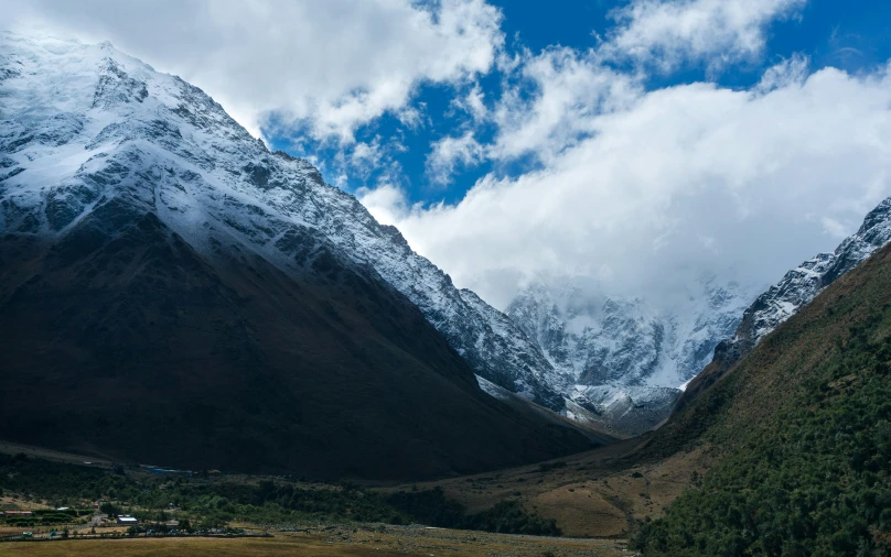 the mountains are surrounded by snow - capped clouds