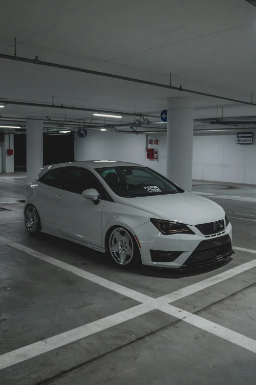 a white car sits in a parking garage