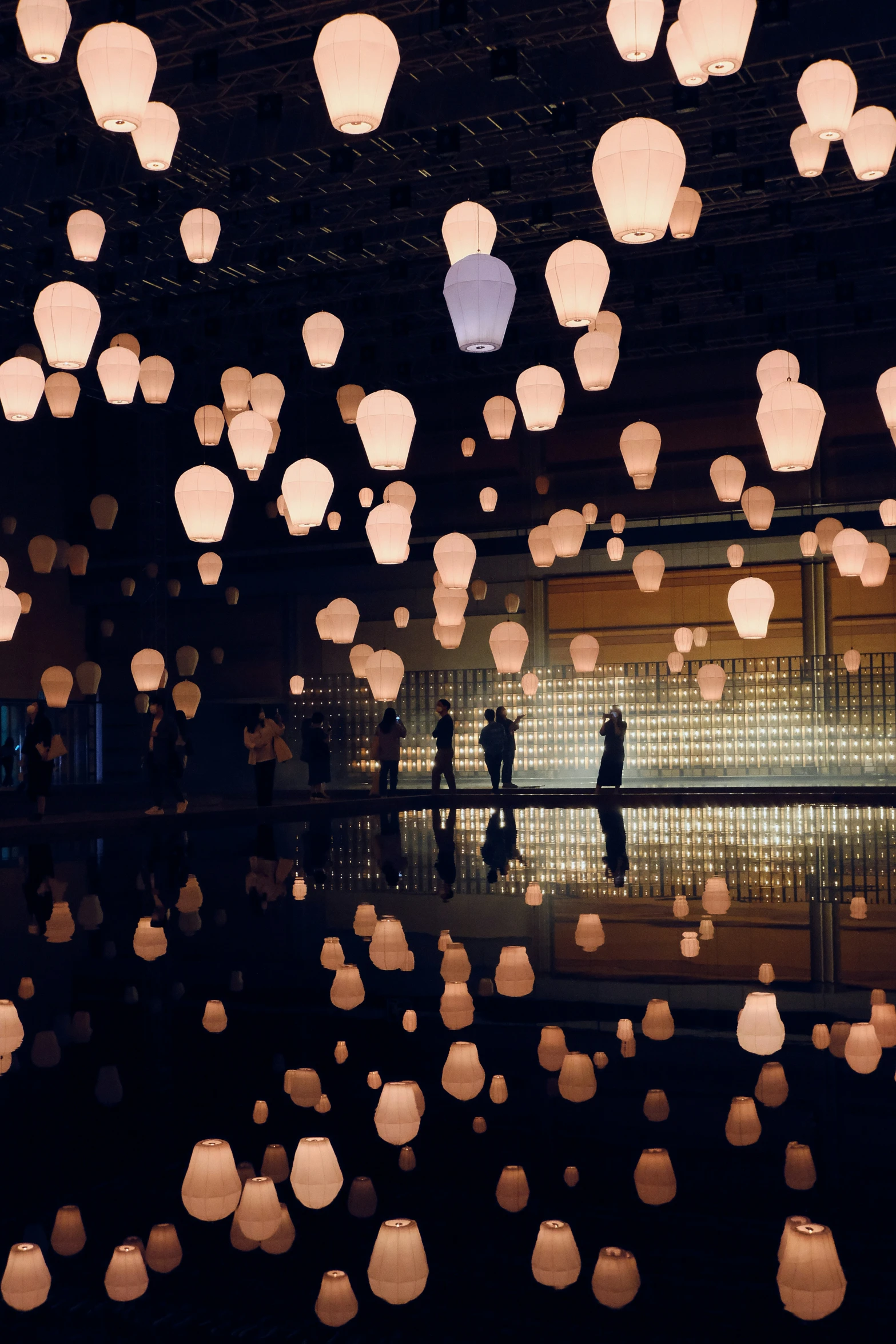 people in the middle of a room filled with lanterns