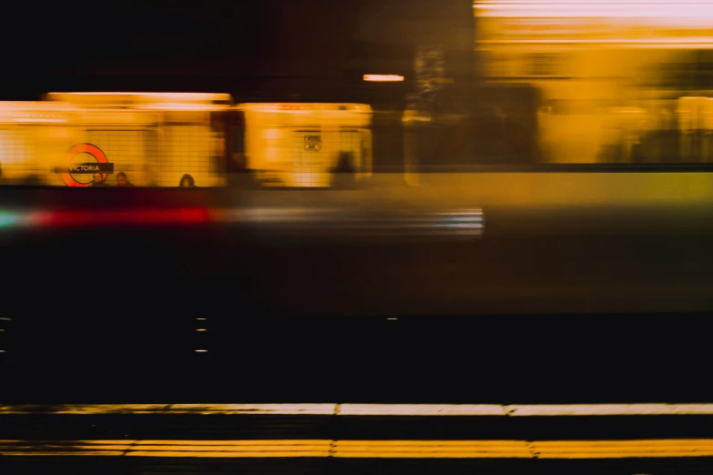 blurry image of a building at night with a train passing by