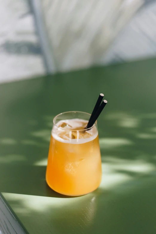 a glass with an orange drink and a straw