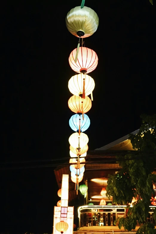 there are many lanterns hanging from poles at night