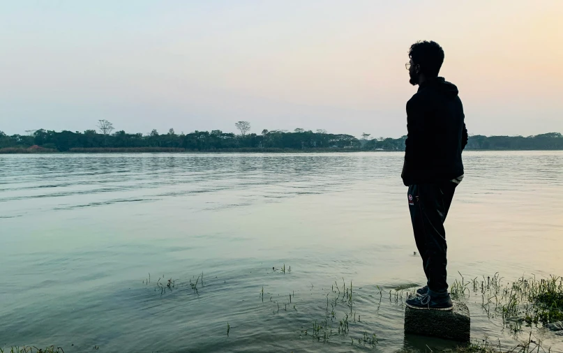 a man stands on a rock in the water