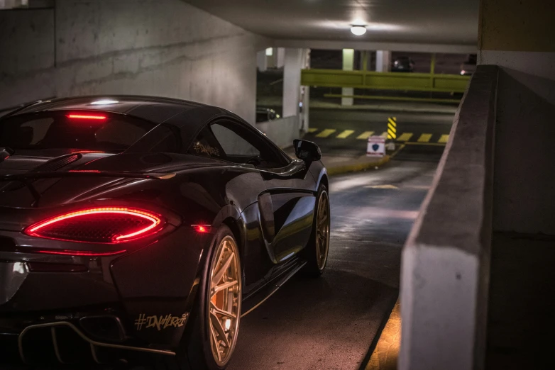 the rear end of a sports car in a parking garage