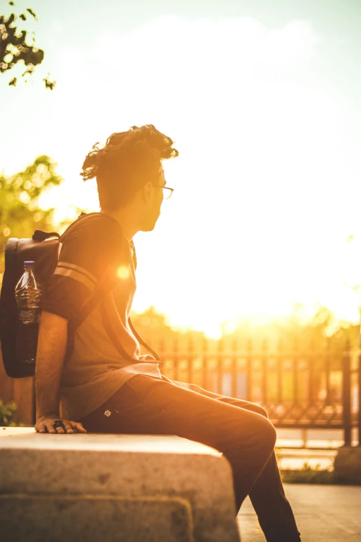 a person sitting on the edge of a concrete bench