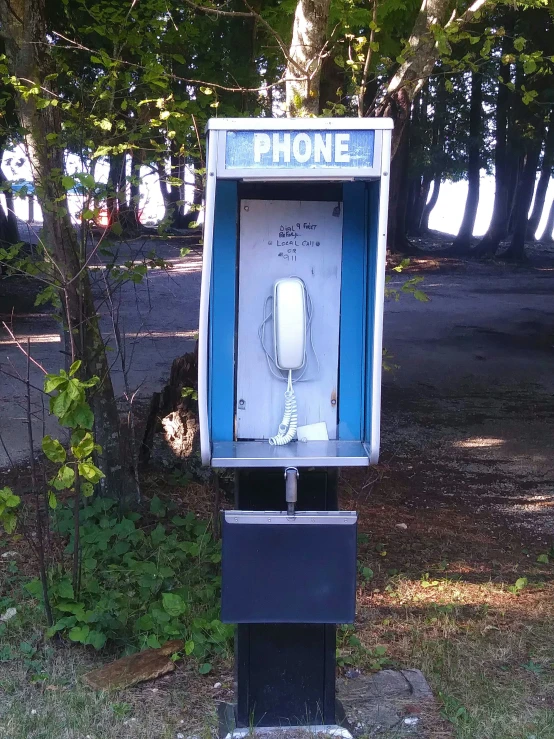 a phone booth with it's open and a phone hooked up to it