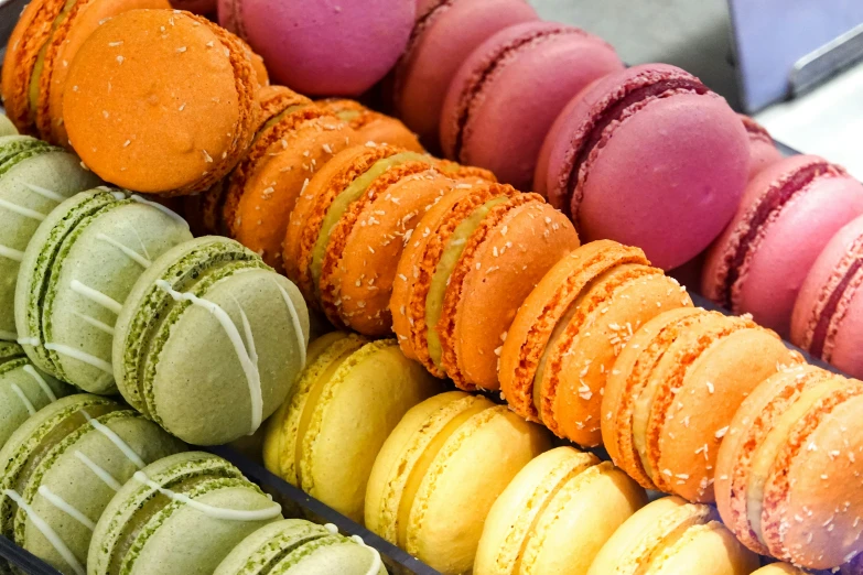 colorfully decorated macaroons sitting on display in a box