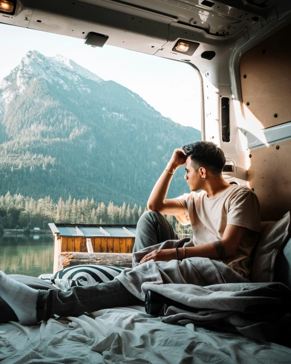 a young man sitting in the backseat of an rv looking out