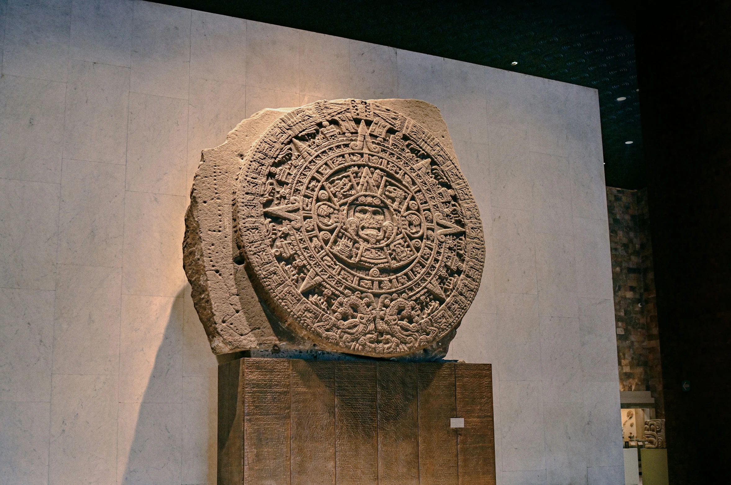 a stone slab on display with a clock and another item in the background