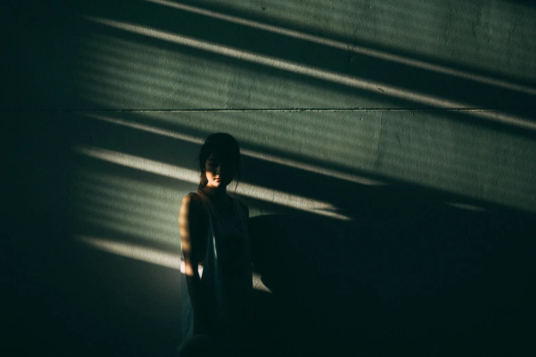 a person standing next to the wall in a dark room