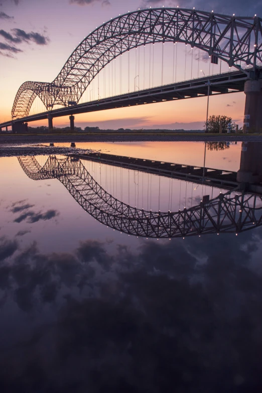 a bridge is seen over water with a sunset