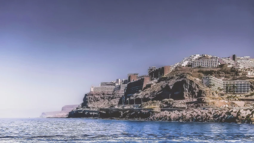 a rocky, small island near the ocean with lots of buildings