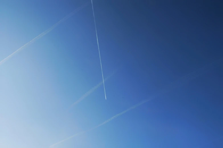 an airplane flies overhead with a trail of smoke coming from the top