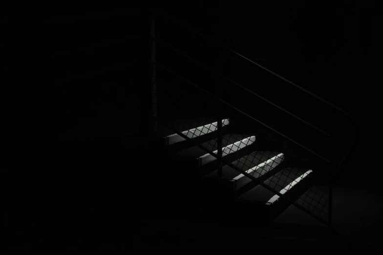 there is a stairway in the dark with light coming through