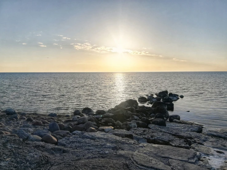 the sun shines on the water and rocks