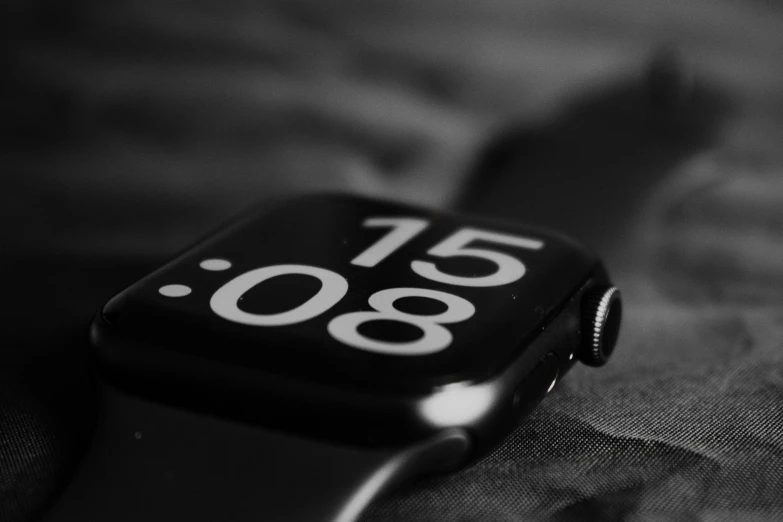 close up of a black and white apple watch with a strap on the wrist