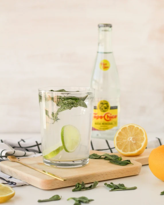 a glass of lemon water with slices of lime and an orange