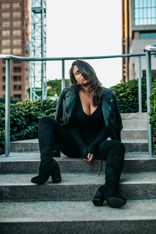a woman sitting down on steps wearing black