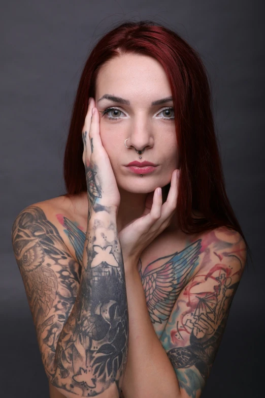 a tattooed woman poses for a po