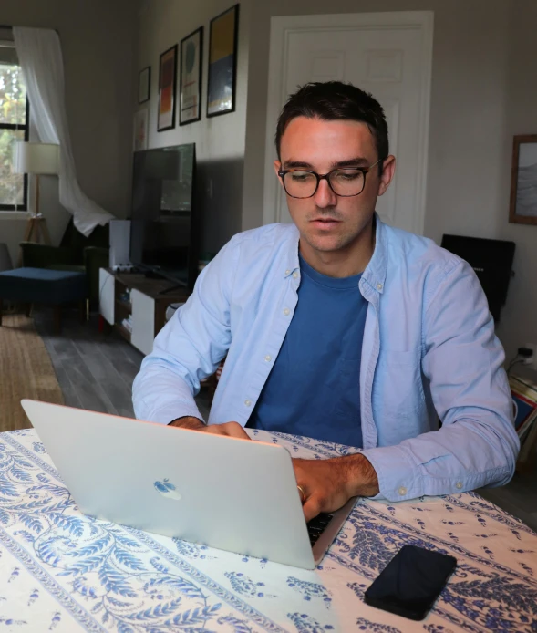 man using his laptop computer while sitting at a table