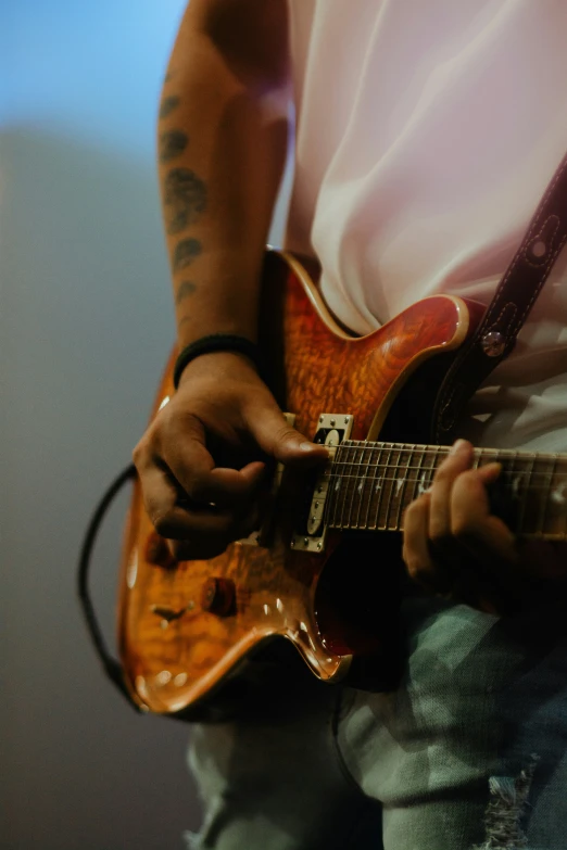 a close up of a person playing an electric guitar