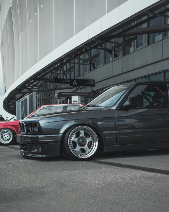 a black bmw car parked next to an orange mustang