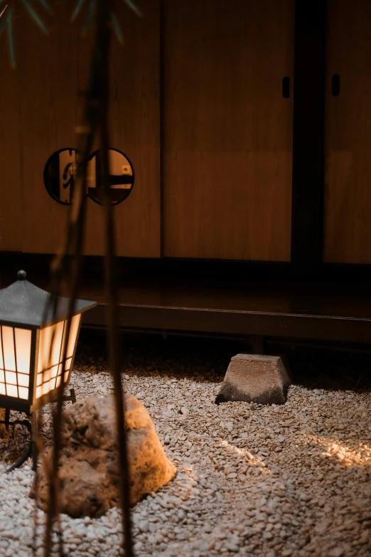 a lantern is lit up next to a stone