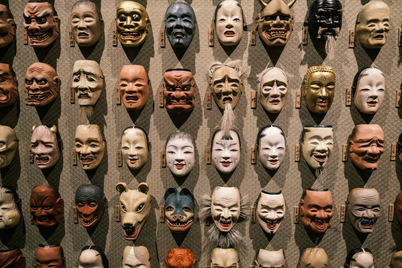 several rows of different colored masks with open mouths