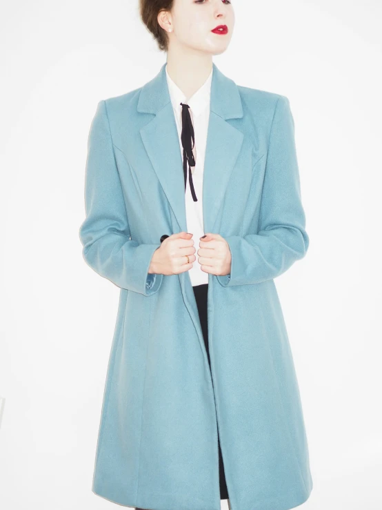 a woman is wearing a light blue jacket