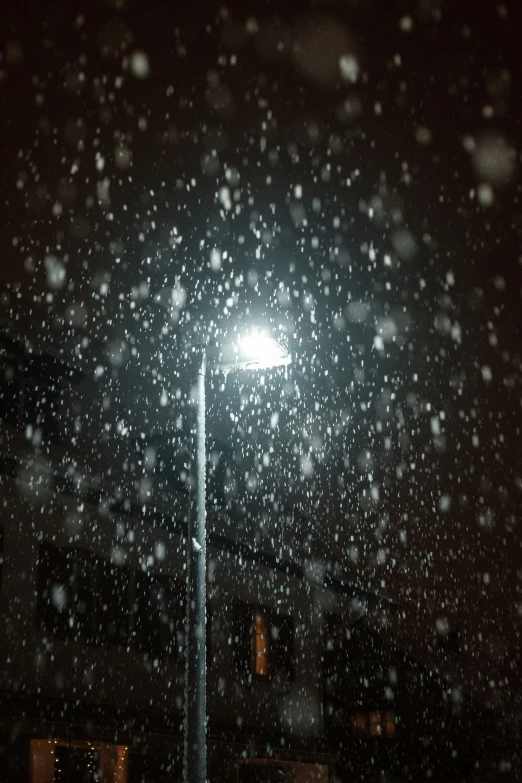 a street light surrounded by snow in the night