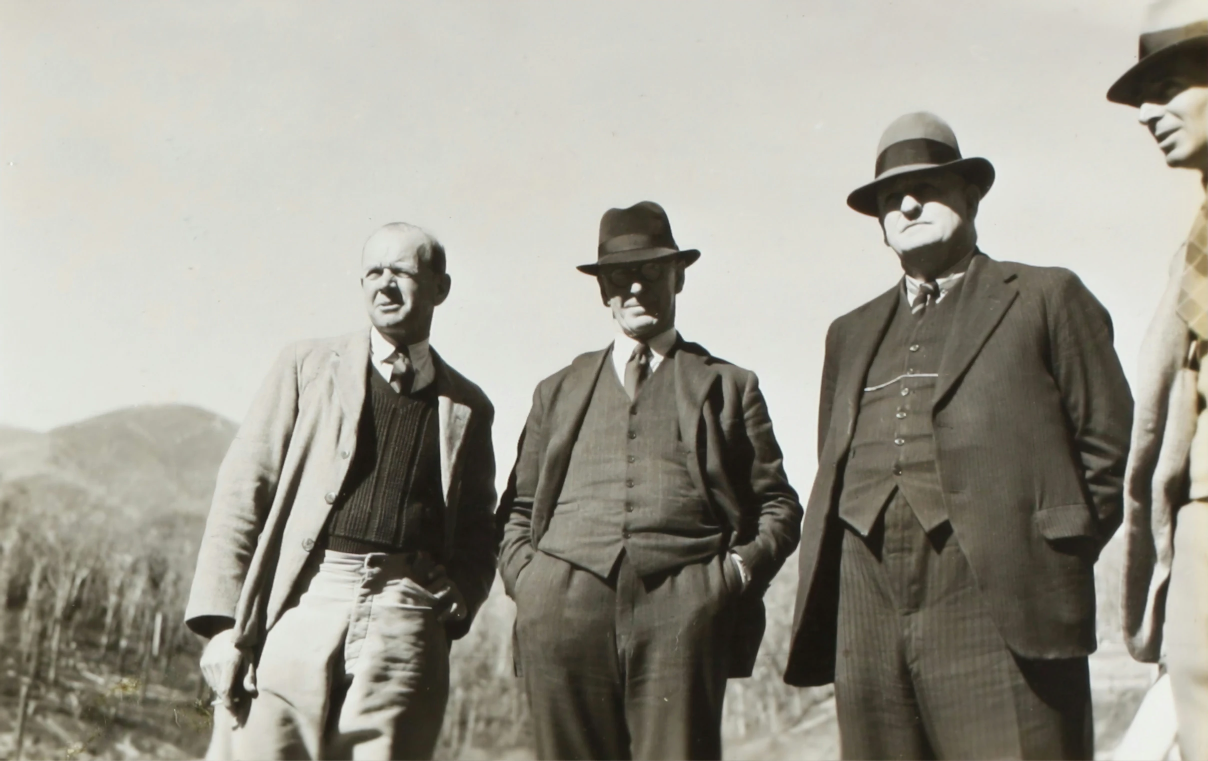 three men wearing hats and suits and suits