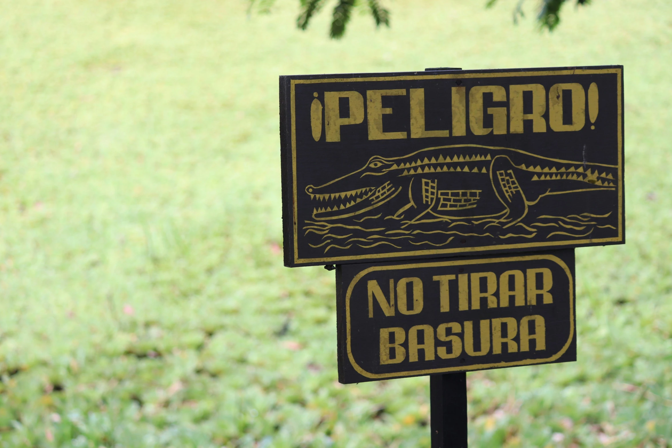 a sign on the side of a wooden post near a field