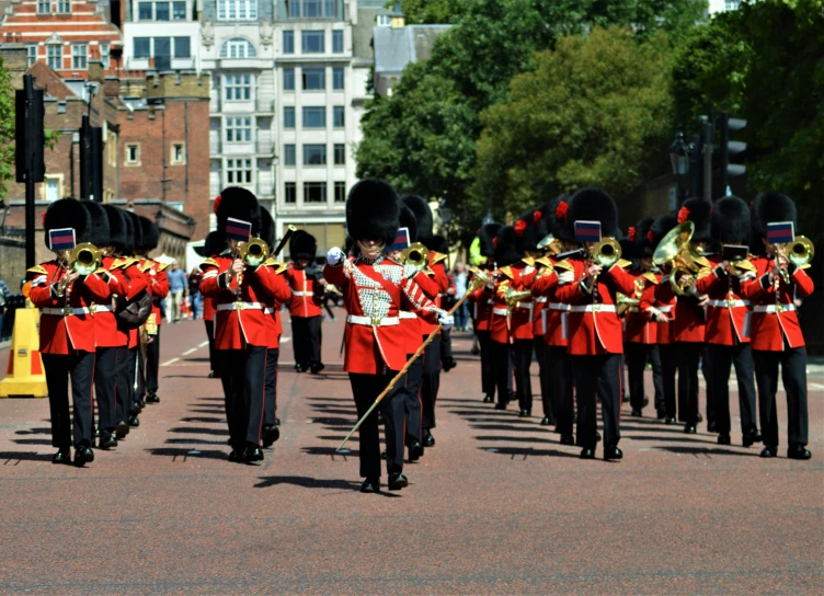 men in red and black outfits are marching through the street