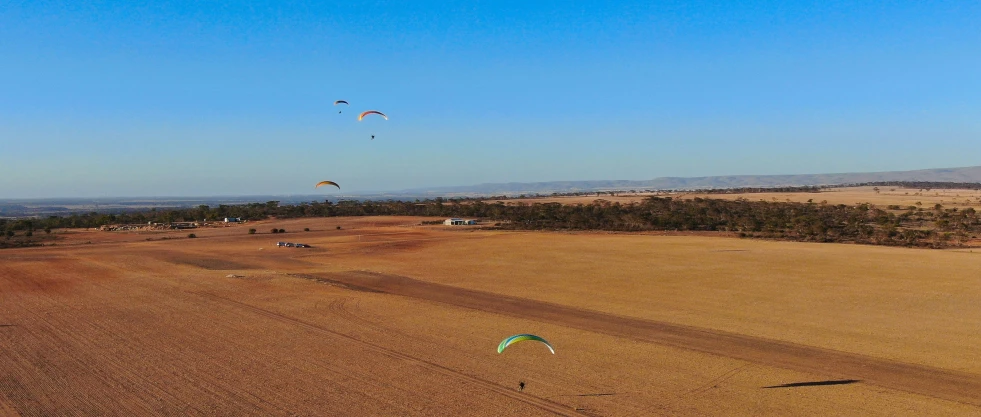 a view of two parasailers from above flying over an area