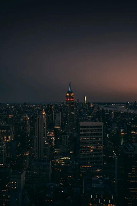 the top of a tall skyscr is lit up at night