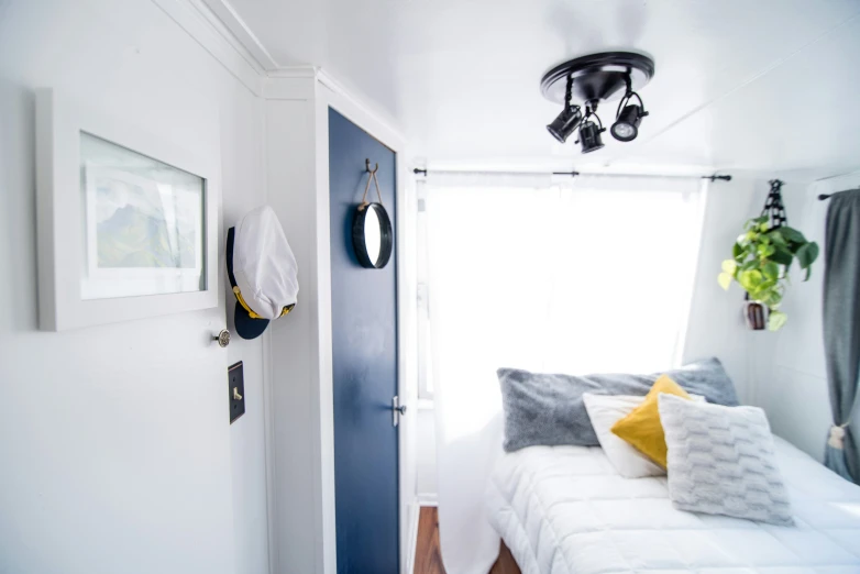 a white bed sitting under a window next to a doorway