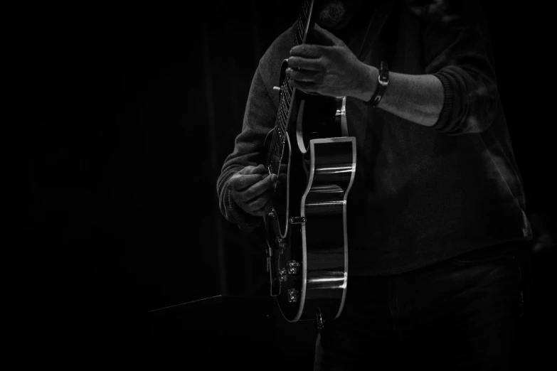 the man is playing a guitar in his hands