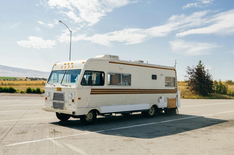 an old camper sits in the middle of a parking lot
