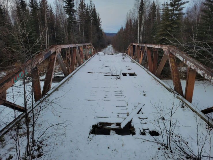 there are some snow on the ground and a bridge over it