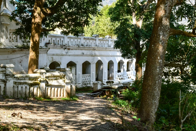 the old house is surrounded by trees in a park