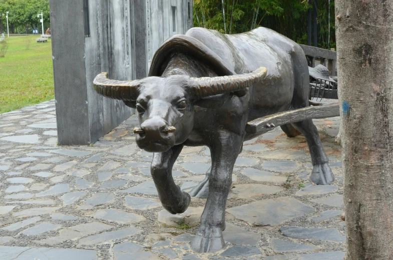 a statue of a bull that is on a stone floor