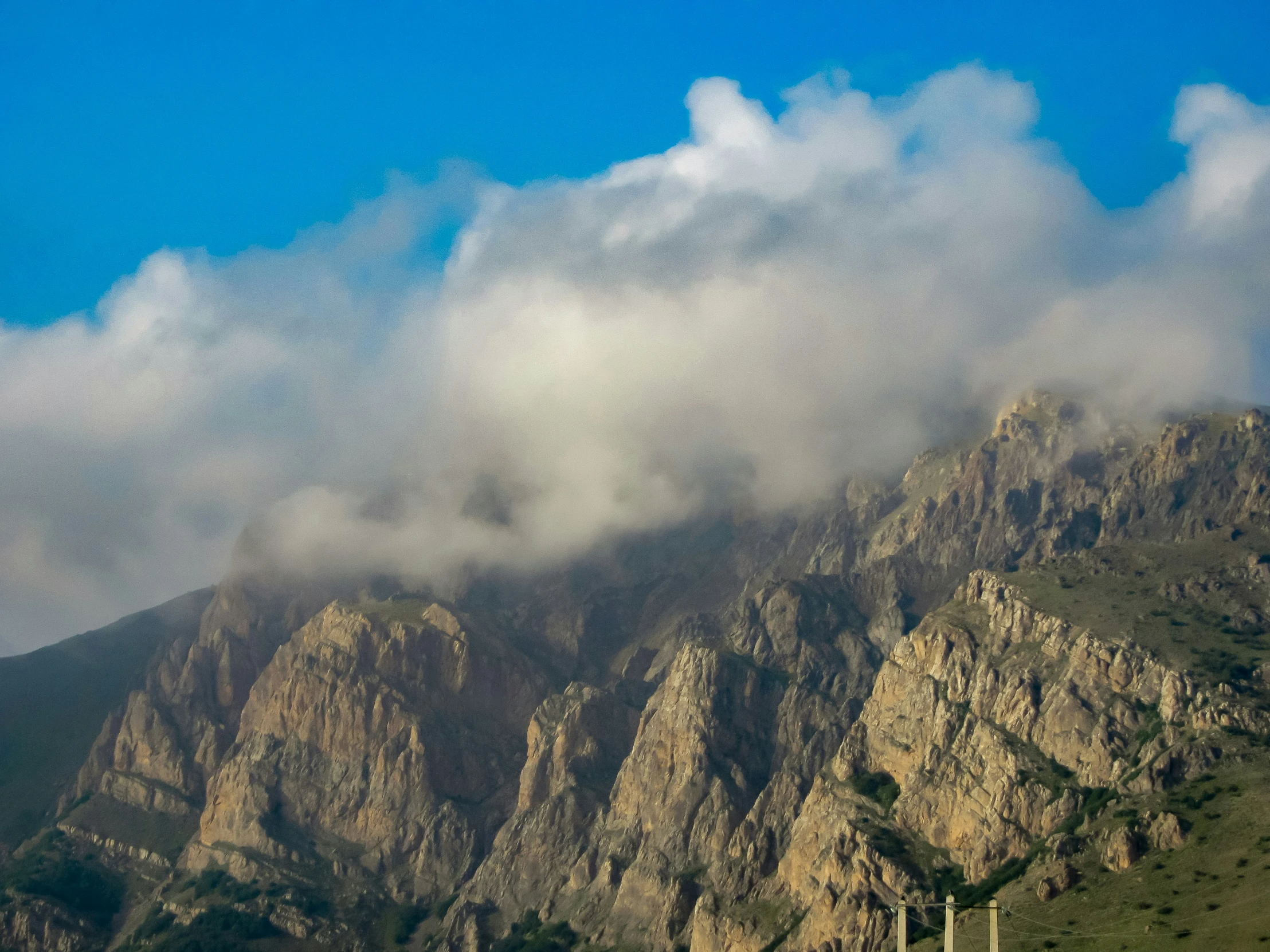 the clouds above a mountain with many trees