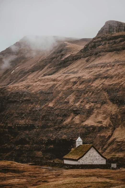a house sitting on the side of a mountain in the mountains