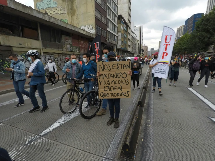 a couple of people holding up signs while standing by a street