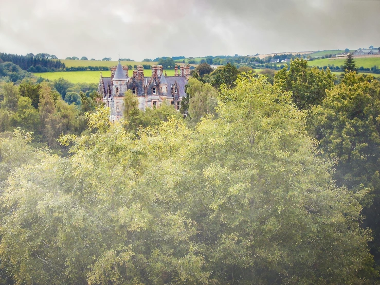 an old stone house seen from a distance in the trees