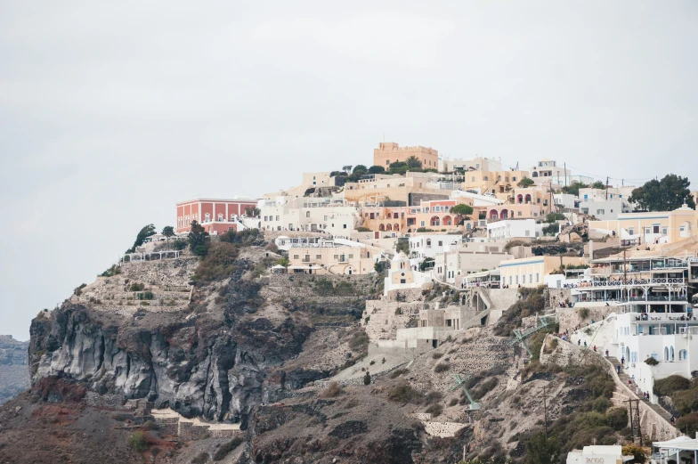 a small mountain with buildings sitting on the edge