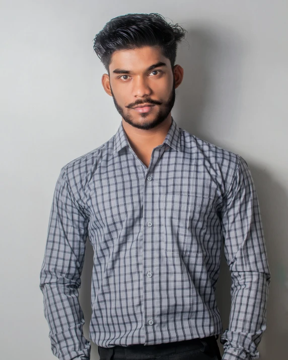 an indian man with a short haircut is wearing a shirt