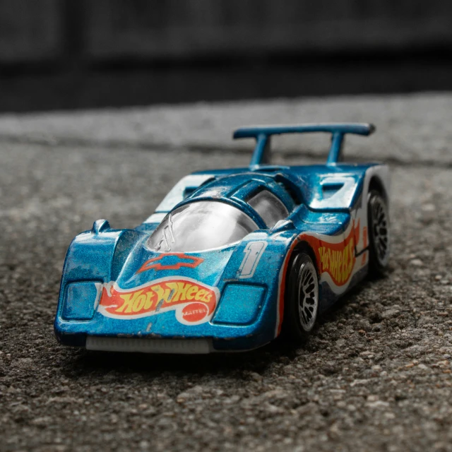 a toy car on a sidewalk with a street background