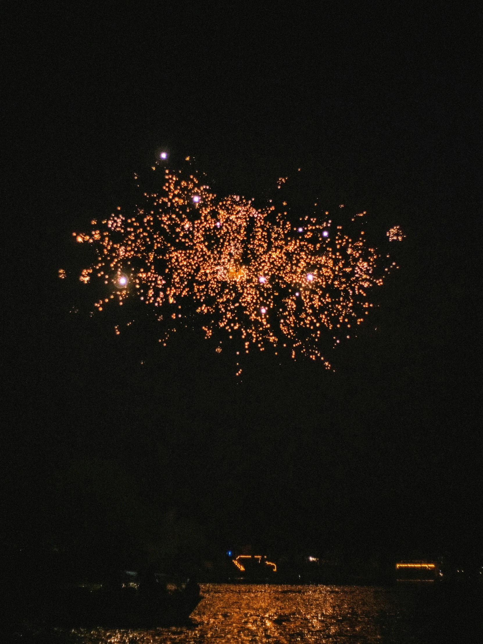 a firework display on a dark evening in the middle of town