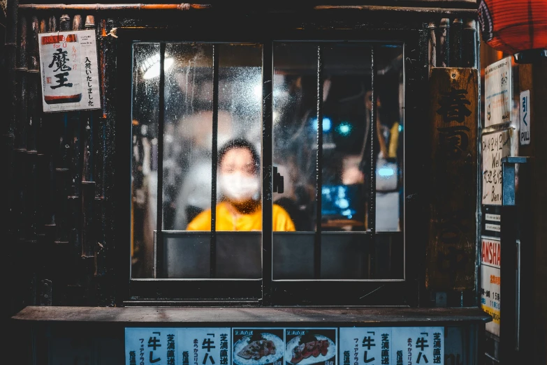 a man sitting behind bars in an open window